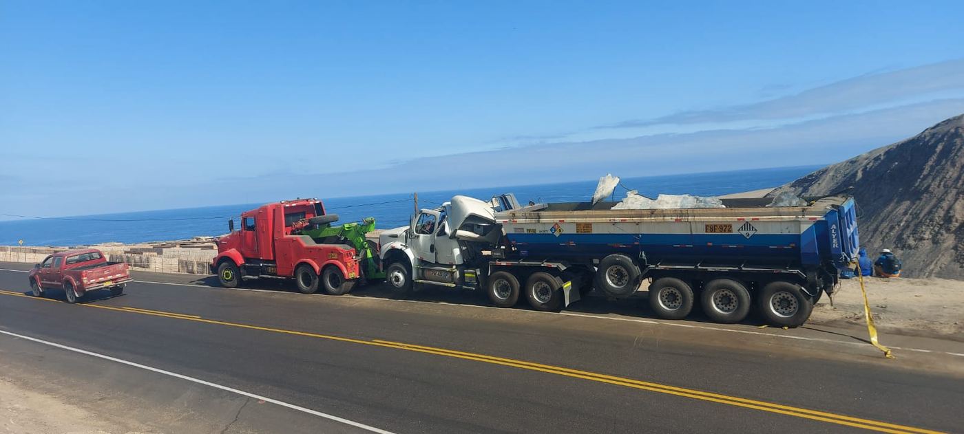 Grúa remolque trasladando un camión por la carretera Panamericana