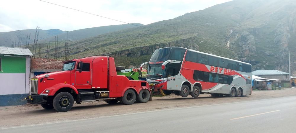 Grúa remolque roja llevando un bus de dos pisos